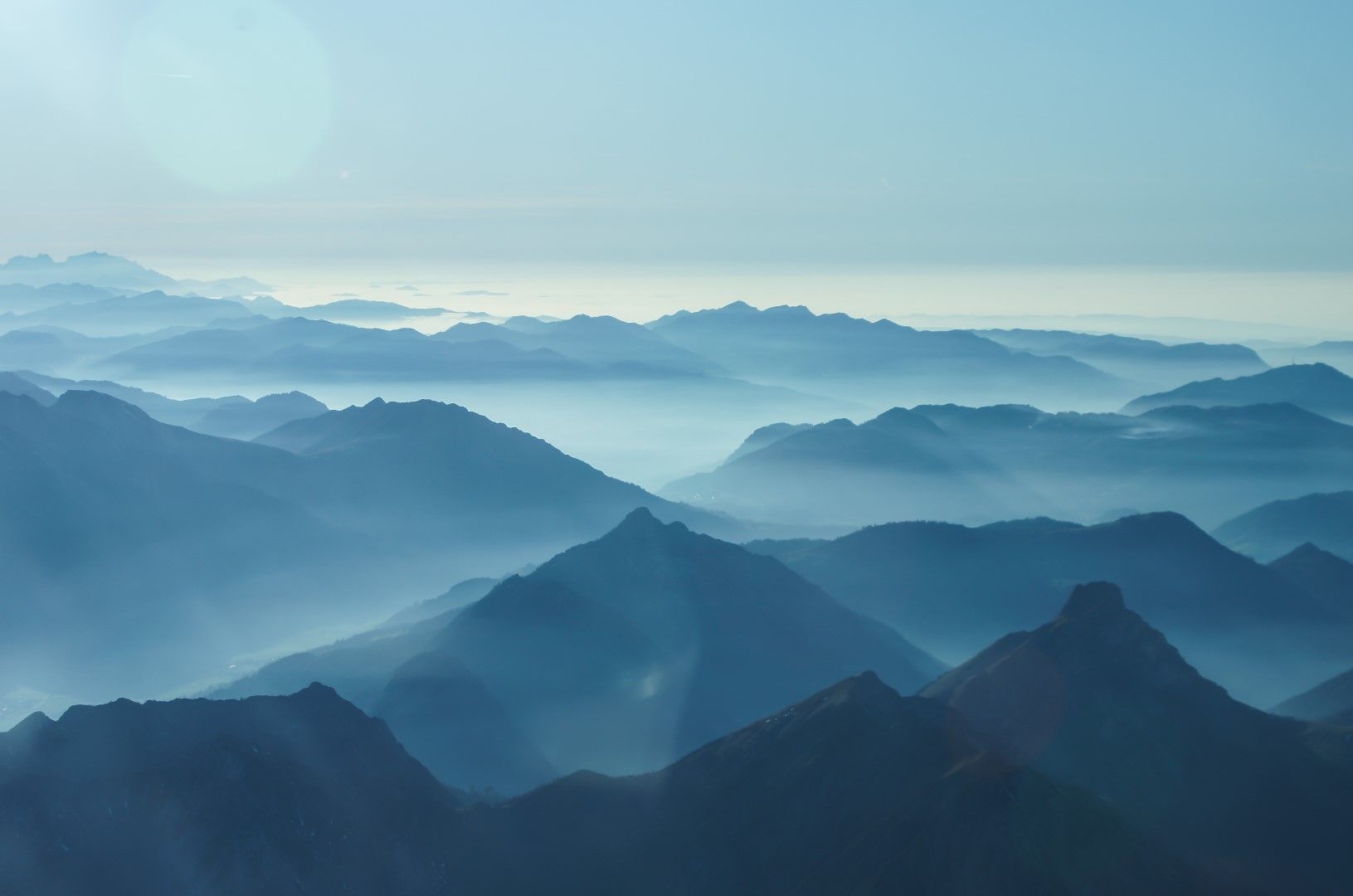 Chaînes de montagnes enveloppées de brume, symbolisant sérénité et prise de recul